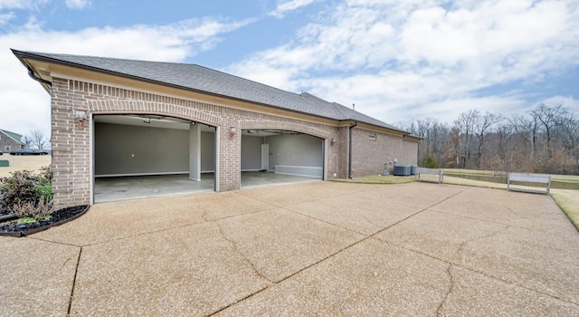 view of home's exterior with cooling unit and a garage