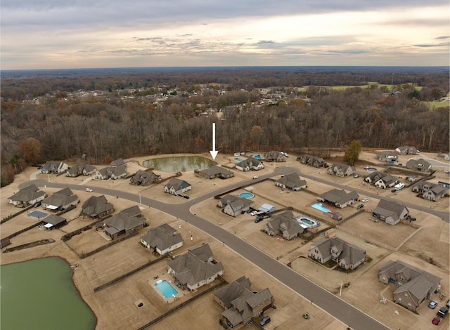 aerial view at dusk featuring a water view