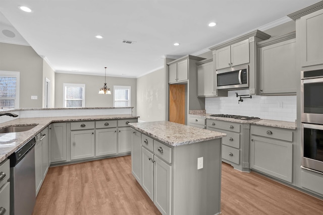 kitchen with sink, light hardwood / wood-style floors, gray cabinets, appliances with stainless steel finishes, and ornamental molding