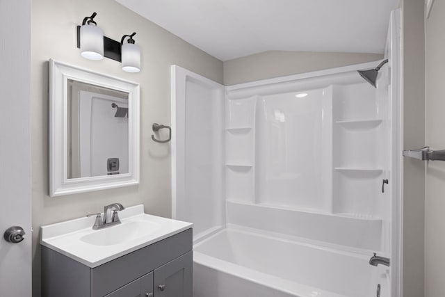 bathroom with vanity, vaulted ceiling, and  shower combination