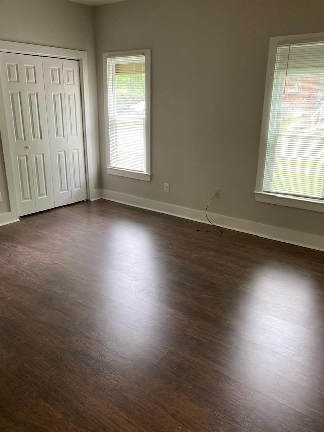 unfurnished bedroom with a closet and dark hardwood / wood-style flooring