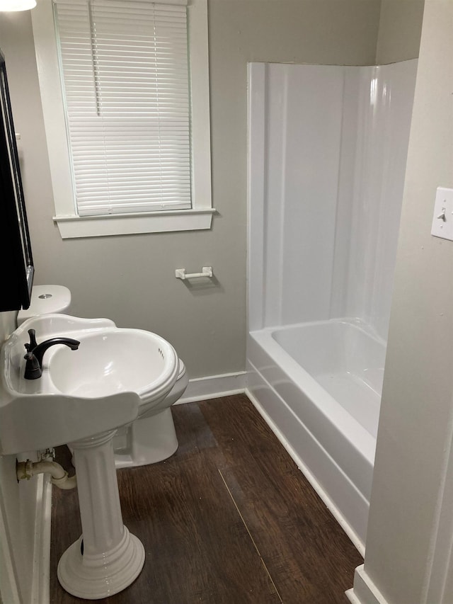 bathroom with wood-type flooring, toilet, and shower / washtub combination