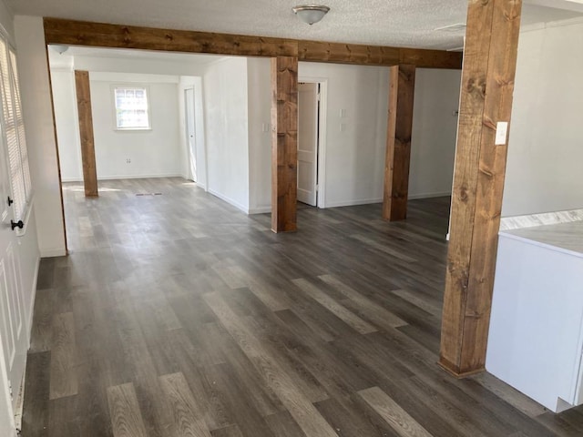 spare room featuring dark wood-type flooring and a textured ceiling