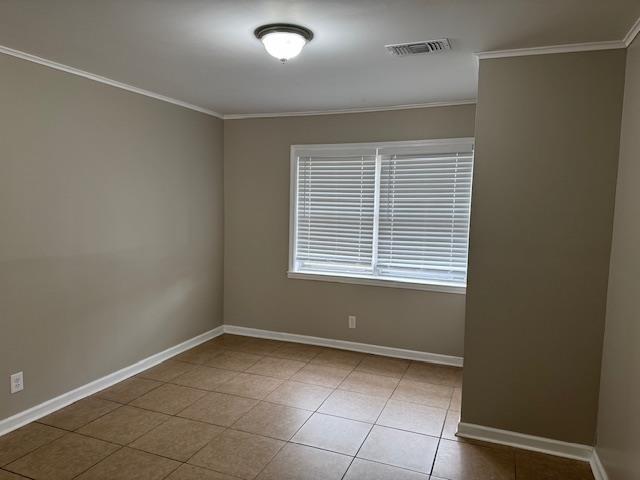 unfurnished room featuring ornamental molding and light tile patterned floors