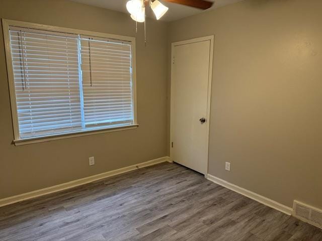 empty room with ceiling fan and hardwood / wood-style floors