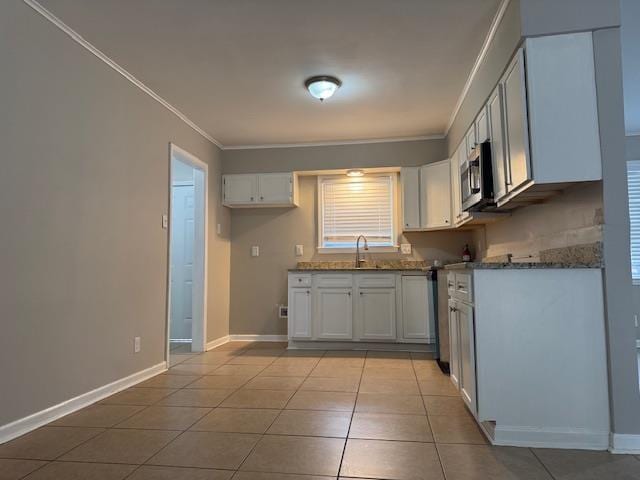 kitchen with white cabinets, light tile patterned floors, and ornamental molding