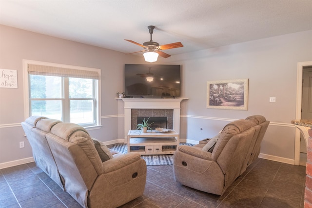 tiled living room with ceiling fan and a fireplace