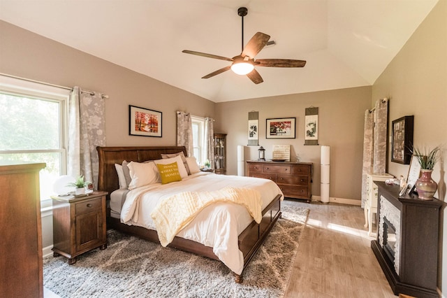 bedroom featuring ceiling fan, light hardwood / wood-style flooring, and vaulted ceiling