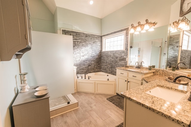 bathroom with plus walk in shower, plenty of natural light, vanity, and hardwood / wood-style floors