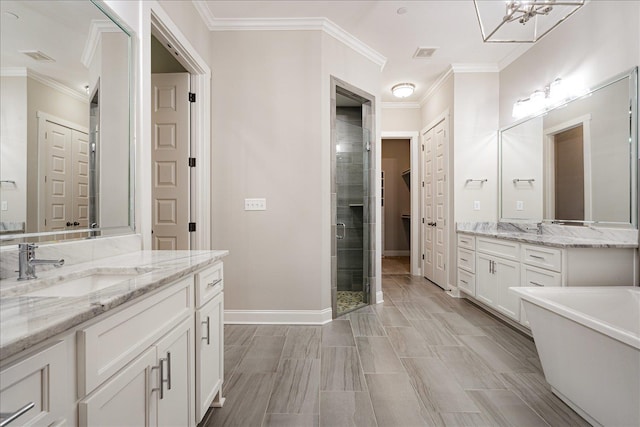 680 Magnolia Ln, Piperton, TN 38017 - bathroom featuring a shower stall, two vanities, ornamental molding, a freestanding tub, and a chandelier