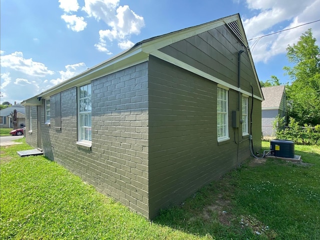 view of side of home featuring a lawn and cooling unit