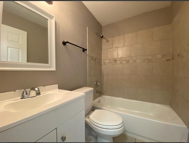 full bathroom with vanity, tiled shower / bath combo, a textured ceiling, and toilet