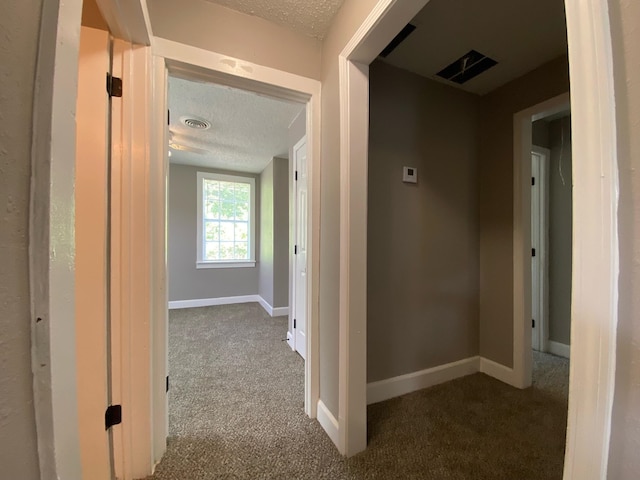 corridor with carpet flooring and a textured ceiling