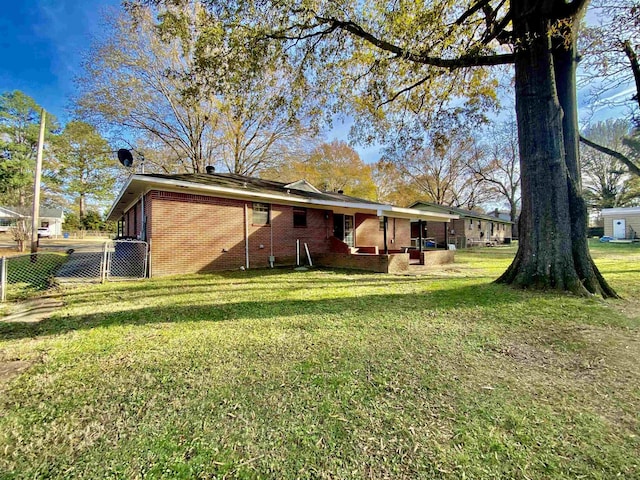 rear view of house featuring a yard