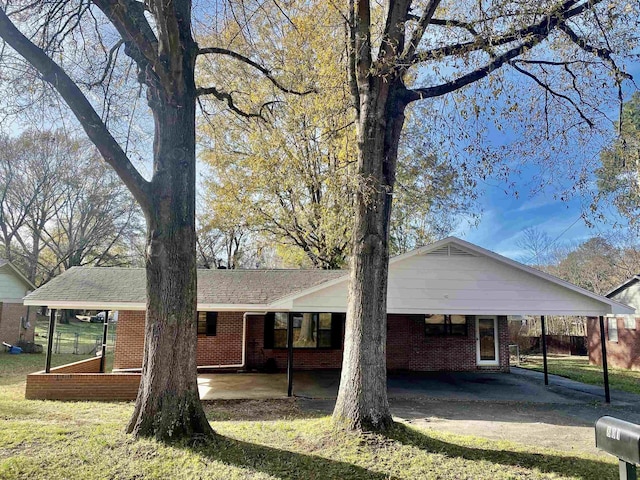 ranch-style home with a front lawn and a carport