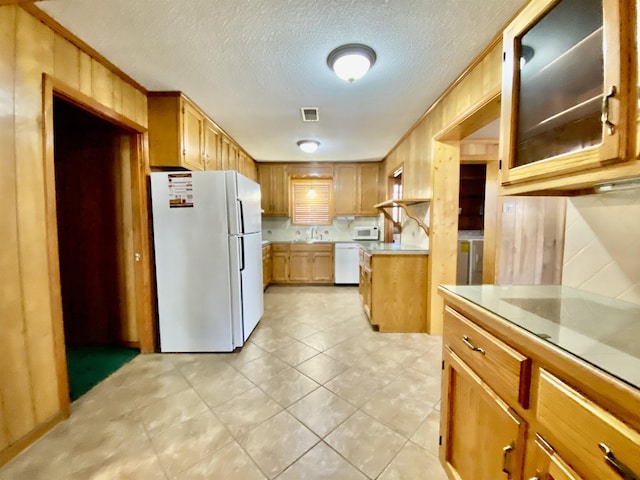 kitchen featuring a textured ceiling, white appliances, sink, and washer / clothes dryer