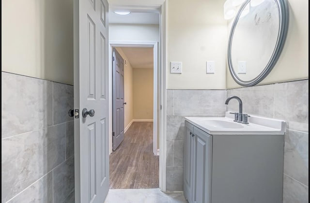 bathroom featuring hardwood / wood-style floors, vanity, and tile walls