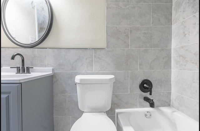 full bathroom with vanity, toilet, tile walls, and bathing tub / shower combination