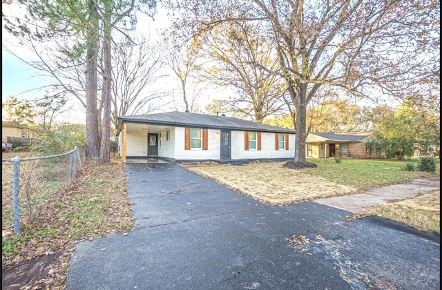 ranch-style house featuring covered porch and a front lawn