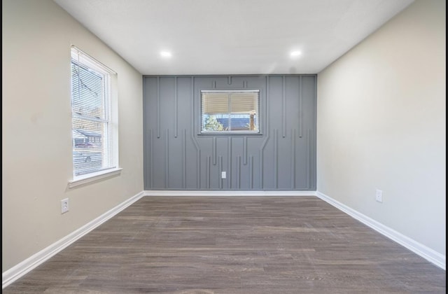 empty room with plenty of natural light and dark wood-type flooring