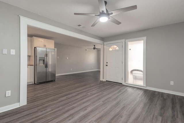 unfurnished living room featuring ceiling fan and dark hardwood / wood-style flooring