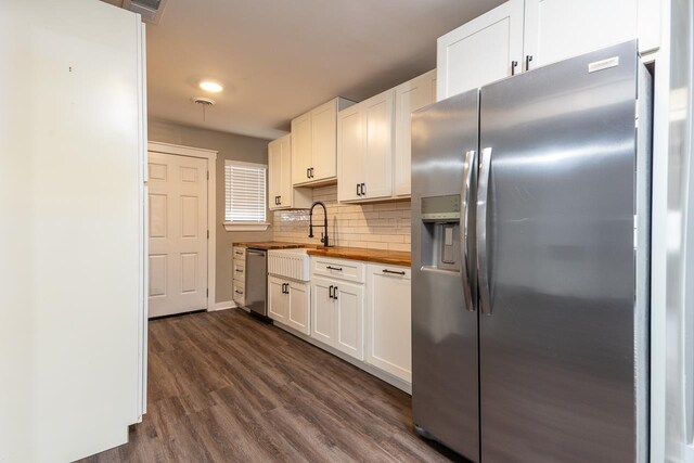 kitchen with wood counters, appliances with stainless steel finishes, white cabinets, and dark hardwood / wood-style floors