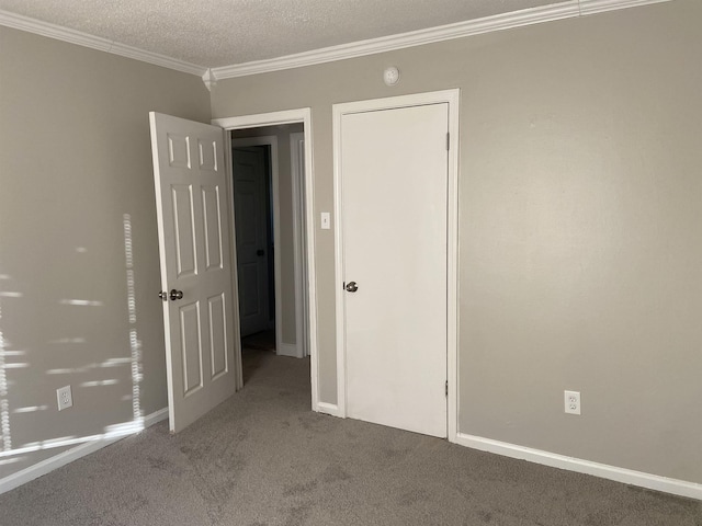 unfurnished bedroom featuring a textured ceiling, carpet floors, and crown molding