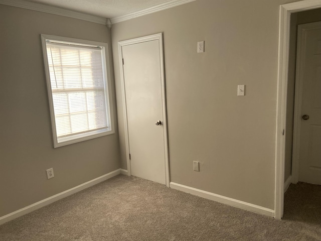 unfurnished bedroom with carpet flooring, ornamental molding, and a textured ceiling