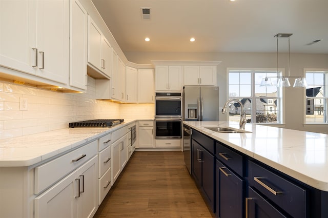 kitchen with sink, stainless steel appliances, white cabinetry, and pendant lighting