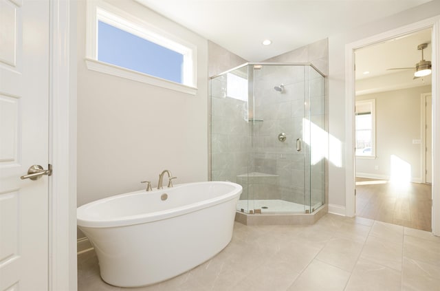 bathroom with a healthy amount of sunlight, separate shower and tub, tile patterned flooring, and ceiling fan