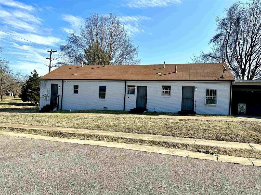 rear view of house with a carport and a lawn