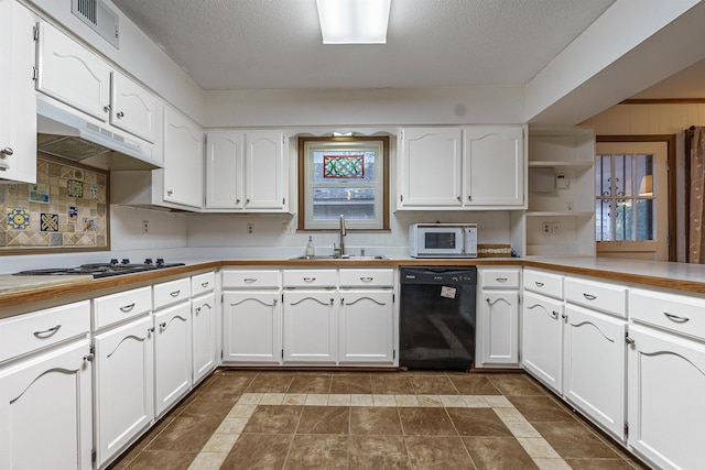 kitchen with stainless steel gas stovetop, sink, decorative backsplash, black dishwasher, and white cabinetry