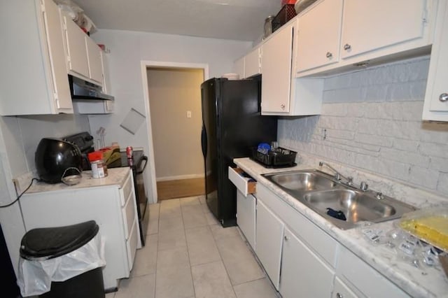 kitchen with tasteful backsplash, sink, light tile patterned floors, and white cabinets