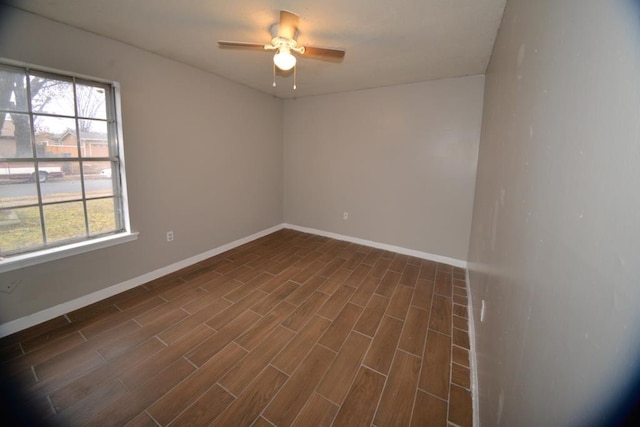 unfurnished room featuring ceiling fan, a wealth of natural light, and dark hardwood / wood-style flooring