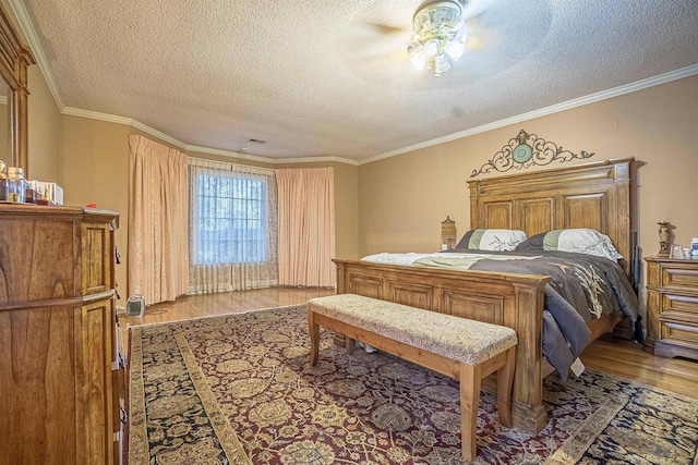 bedroom with a textured ceiling, wood-type flooring, ornamental molding, and ceiling fan