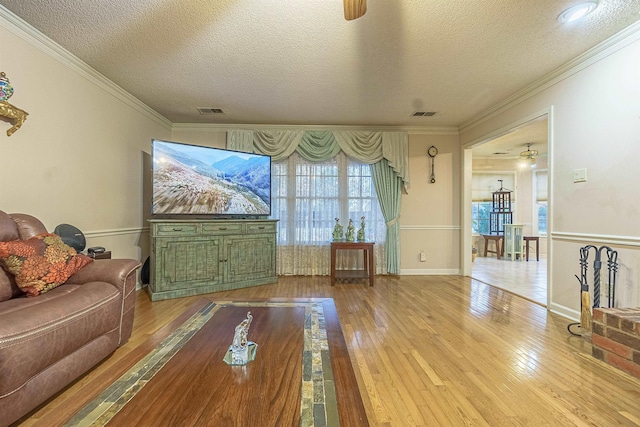 living room featuring ceiling fan, light hardwood / wood-style floors, and a textured ceiling