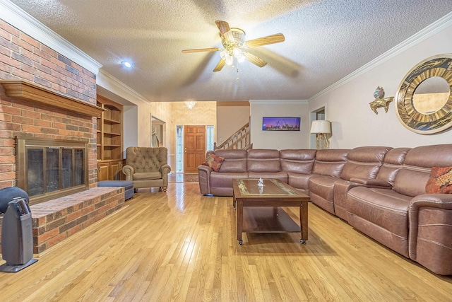 living room featuring crown molding, built in features, a textured ceiling, and light hardwood / wood-style flooring