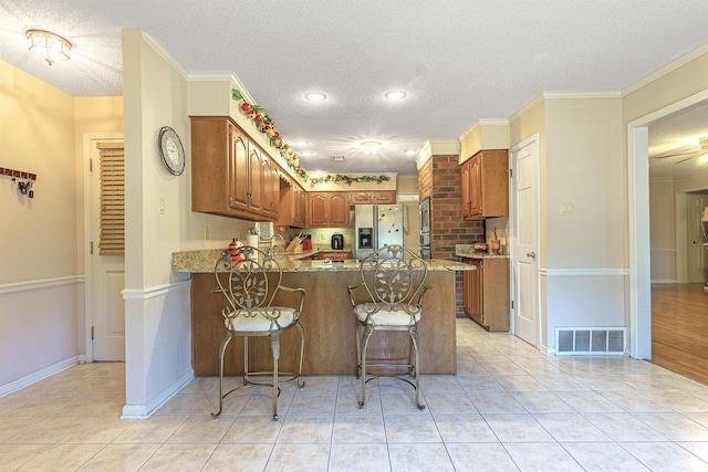 kitchen with crown molding, appliances with stainless steel finishes, a textured ceiling, and kitchen peninsula