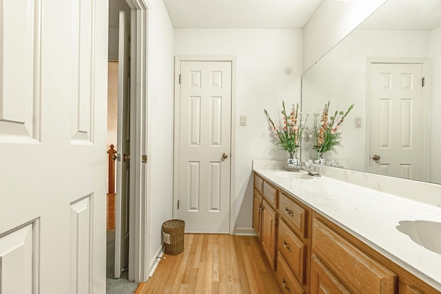 bathroom with vanity, hardwood / wood-style floors, and a textured ceiling