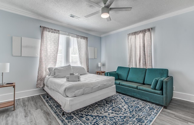 bedroom featuring a textured ceiling, hardwood / wood-style flooring, ceiling fan, and crown molding