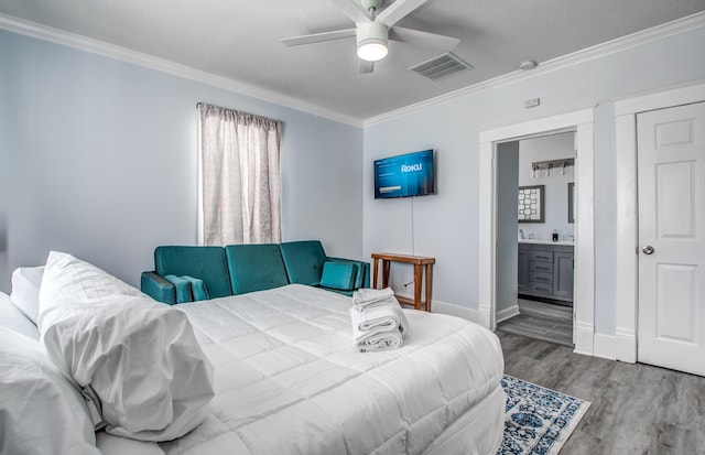 bedroom featuring ensuite bath, ceiling fan, a textured ceiling, hardwood / wood-style flooring, and ornamental molding