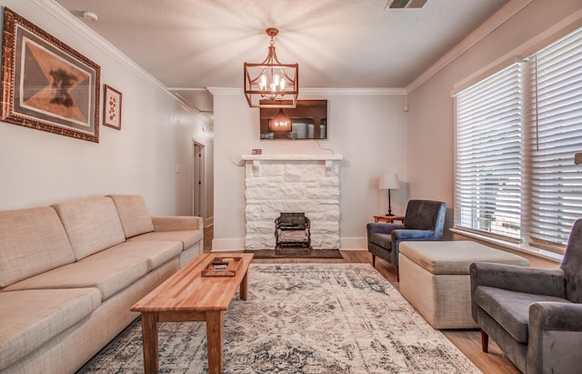 living room with a textured ceiling, a notable chandelier, light wood-type flooring, and crown molding