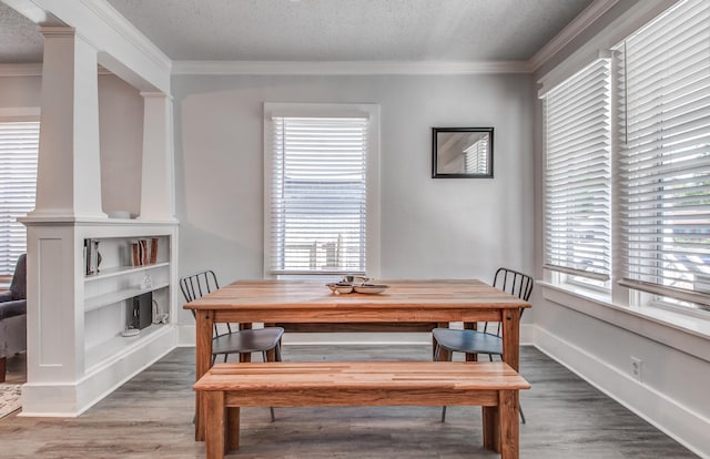 dining area featuring a textured ceiling, hardwood / wood-style flooring, and ornamental molding