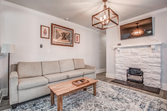 living room featuring dark hardwood / wood-style floors, ornamental molding, a fireplace, and a chandelier