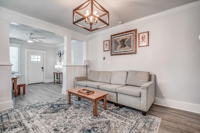 living room with a textured ceiling, ceiling fan with notable chandelier, hardwood / wood-style flooring, and ornamental molding