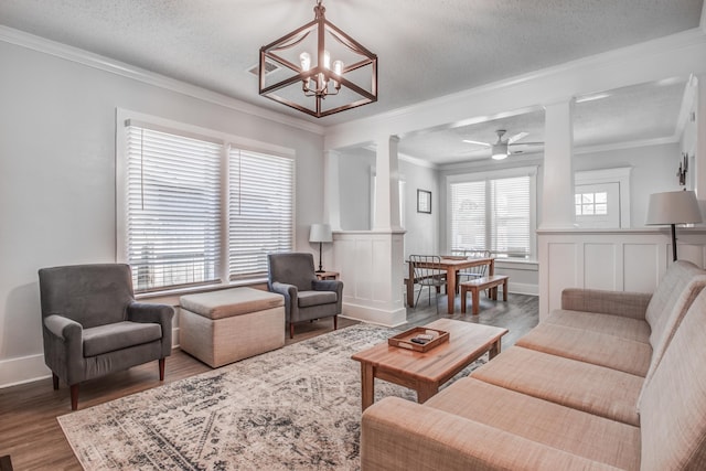 living room with hardwood / wood-style flooring, ornate columns, and ornamental molding