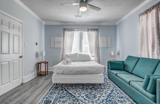 bedroom with hardwood / wood-style flooring, ceiling fan, crown molding, and a textured ceiling