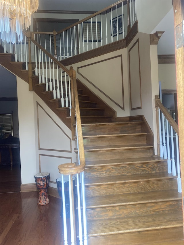 stairway featuring hardwood / wood-style flooring and a notable chandelier