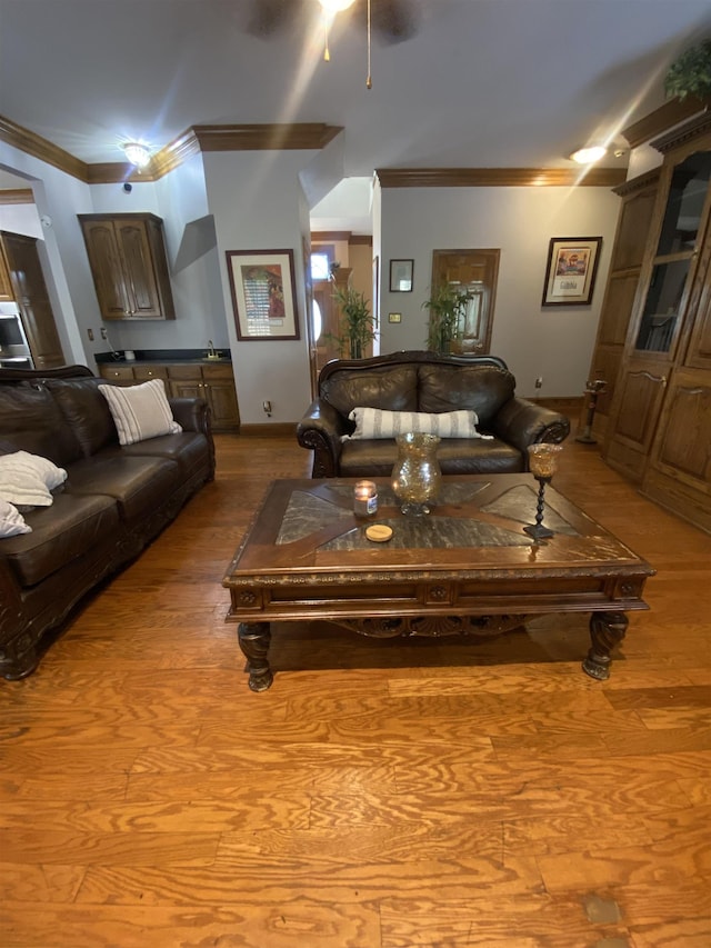 living room with light hardwood / wood-style floors, ceiling fan, and crown molding