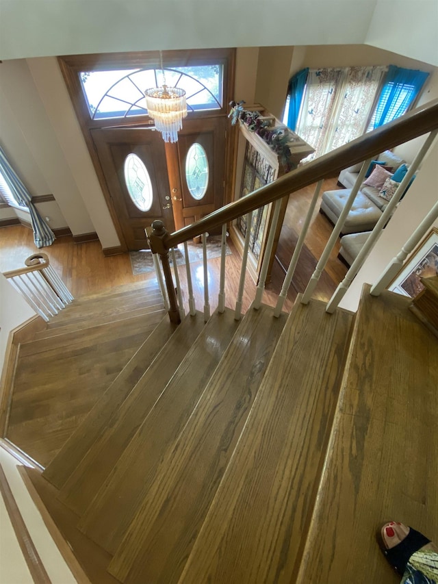 staircase featuring a chandelier and wood-type flooring